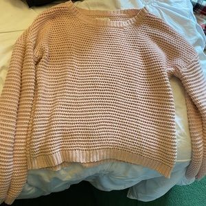 A light pink sweater, worn but appears new.